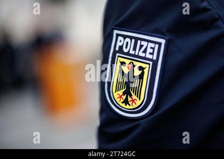 München, Deutschland. November 2023. Das nationale Emblem der Bundespolizei, ein Wappen mit dem Wort Polizei und einem Adler, ist auf dem Ärmel der Uniform eines Bundespolizisten zu sehen. Quelle: Matthias Balk/dpa/Alamy Live News Stockfoto