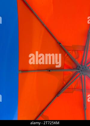 Flacher Blick auf den orangefarbenen Strand oder den Sonnenschirm am Pool vor blauem Himmel, Urlaubs- oder Urlaubskonzept Stockfoto