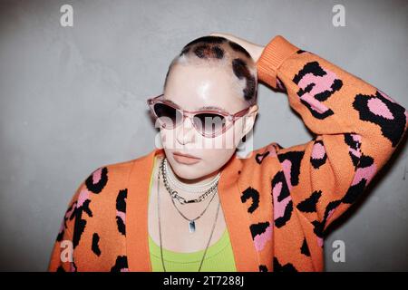 Porträt einer selbstbewussten jungen Frau mit Gepardendruck und Sonnenbrille im Studio Stockfoto