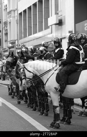 Polizei im Dienst in Zentral-London. Schwarzweiß. Schwarzweiß. Die dünne blaue Linie. Cops. Alte Rechnung. Crowd Control. Straßen. Uniformpolizisten. Sonderbereiche. Montiert. Hunde. K9. Montiert. Pferde. Aufruhr-Polizei. Recht und Ordnung. Frieden. Stockfoto