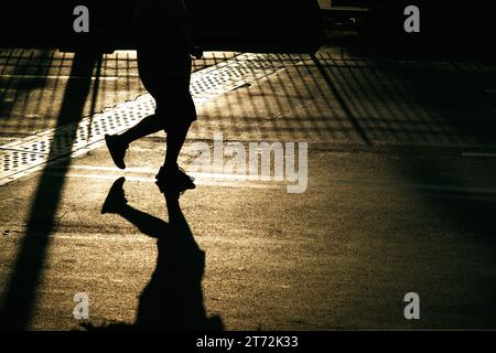 Izmir, Türkei, 10. September 2023: Läufer werden während des Izmir-Marathons zu Silhouetten gegen das helle Sonnenlicht auf dem Asphalt Stockfoto