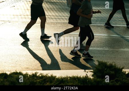 Izmir, Türkei, 10. September 2023: Läufer werden während des Izmir-Marathons zu Silhouetten gegen das helle Sonnenlicht auf dem Asphalt Stockfoto