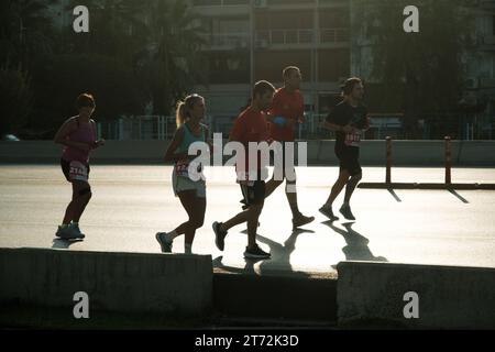 Izmir, Türkei, 10. September 2023: Läufer werden während des Izmir-Marathons zu Silhouetten gegen das helle Sonnenlicht auf dem Asphalt Stockfoto