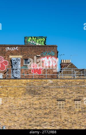 Der obere Teil eines Ziegelgebäudes, das mit Graffiti bedeckt ist Stockfoto