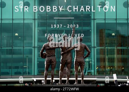 Ein Blick auf die United Trinity Statue von Sir Bobby Charlton, Denis Law und George Best vor Old Trafford in Manchester während der Trauerprozession für die Manchester United und England großen Sir Bobby Charlton, der im Oktober im Alter von 86 Jahren starb. Charlton erzielte 249 Tore für Manchester United und half ihnen, drei Meistertitel, einen FA Cup und den Europapokal 1968 zu gewinnen. Auf internationaler Ebene war er Teil der englischen Mannschaft, die 1966 die Weltmeisterschaft gewann. Bilddatum: Montag, 13. November 2023. Stockfoto