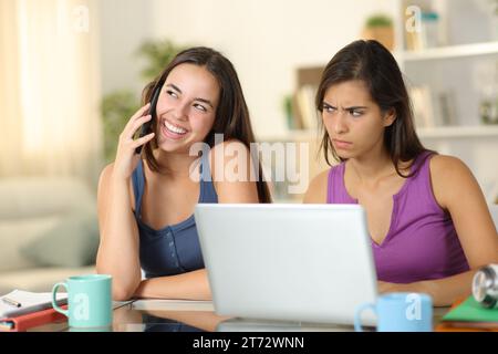 Ein verdächtiger Schüler hört einem Freund zu, der zu Hause telefoniert Stockfoto