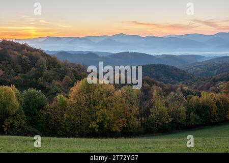 Herbstwald bei Sonnenaufgang mit wunderschönem farbenfrohen Himmel. Berglandschaft. Die Natur europas. Vrsatec, Slowakei. Stockfoto
