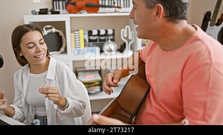 Selbstbewusste hispanische Musiker singen und spielen leidenschaftlich klassische Gitarre in einem lebhaften Musikstudio im Haus Stockfoto