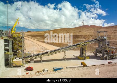 Gesteinsbrecher und Förderband im Werk einer Kupfermine im altiplano der Atacamawüste im Norden Chiles. Stockfoto