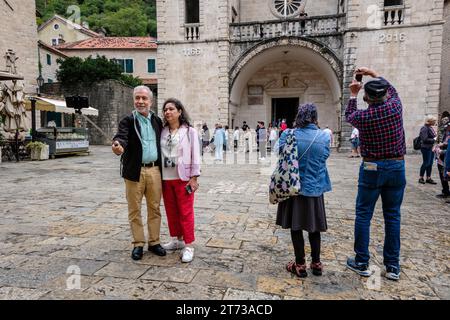Touristen fotografieren auf dem Tryphon-Platz vor der Kathedrale von St. Tryphon, Kotor, Montenegro Stockfoto