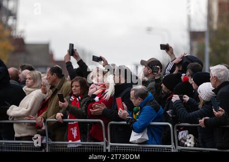 Manchester, Großbritannien. 13. November 2023. Sir Bobby Charlton's Leichenwagen passiert den Old Trafford Football Ground, wo Blumen und Nachrichten an der Gedenkstätte für die Münchner Katastrophe von 1958 hinterlassen wurden. Der Leichenwagen ging an der Trinity Statue vorbei und ging über den Sir Matt Busby Way zum Begräbnis im Stadtzentrum von Manchester. Bild: Garyroberts/worldwidefeatures.com Credit: GaryRobertsphotography/Alamy Live News Stockfoto