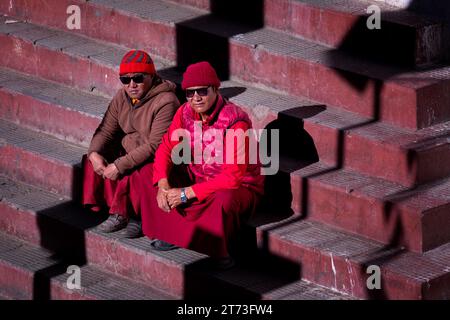 Zwei Mönche sitzen auf der Treppe zum Korzok Kloster, Korzok, Ladakh, Indien Stockfoto