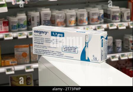 Verpackungsbox Wegovy (Semaglutid) injizierbares verschreibungspflichtiges Medikament, Gewichtsverlust-Medikament von Novo Nordisk AS. Regale im Apothekengeschäft im Hintergrund. Stockfoto