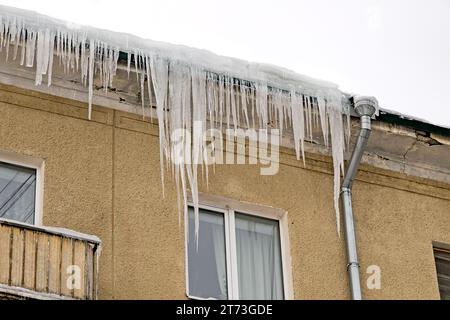 Riesige Eiszapfen hängen vom Dach Stockfoto