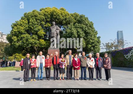 Ältere Menschen, die Shanghai besuchen, posieren für ein Gruppenfoto vor einer Statue von Mao TSE Tong, China. Stockfoto