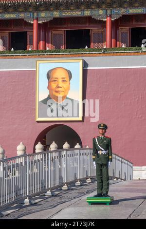 Chinesischer Soldat auf dem Tian'an Men Square, Peking (Peking) China. Hinter ihm hängt das Porträt des ehemaligen chinesischen Führers Mao Zedong. Stockfoto