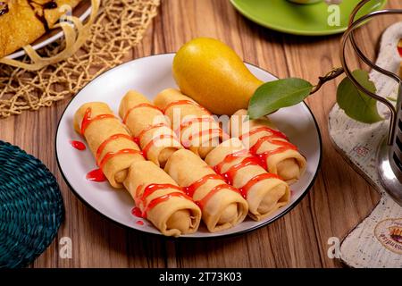 Sieben süße Pfannkuchen auf einer weißen Untertasse auf einem Holztisch Stockfoto