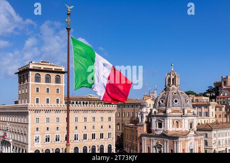 Die italienische Flagge vor der Kirche Santa Maria di Loreto al Foro Traiano auf der rechten Seite, Rom, Latium, Italien Stockfoto