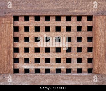 Handwerkskunst aus braunem Holz - altes Gitter mit quadratischen Löchern Stockfoto