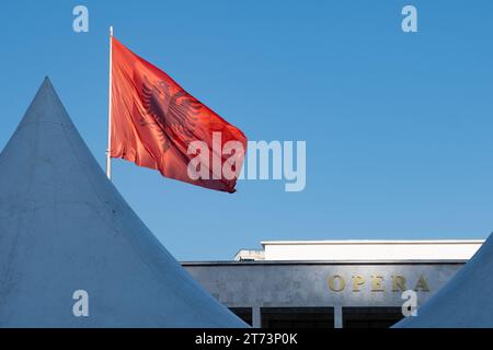 Die albanische Flagge über dem Opernhaus auf dem Skanderbeg-Platz in Tirana, Albanien Stockfoto