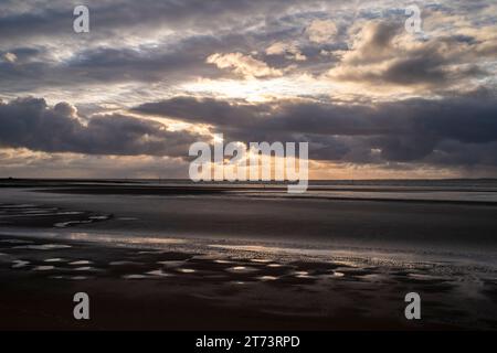 Sonnenstrahlen brechen durch die Wolken über der Morecambe Bay in Morecambe, Lancashire, Großbritannien Stockfoto