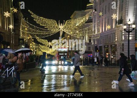 UK Weather, London, 12. November 2023: Die Weihnachtslichter der riesigen Engel auf der Lower Regent Street spiegeln sich in einer regnerischen Nacht am Picadilly Circus im West End auf nassen Straßen. Anna Watson/Alamy Live News Stockfoto