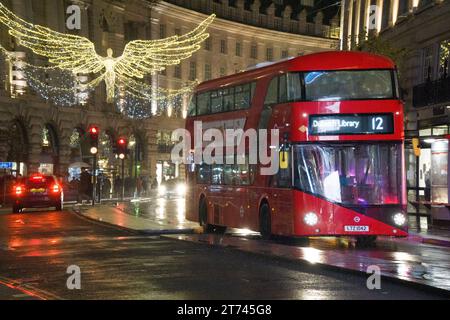 UK Weather, London, 12. November 2023: Weihnachtslichter auf der Regent Street spiegeln sich von nassen Straßen in einer regnerischen Nacht. Anna Watson/Alamy Live News Stockfoto