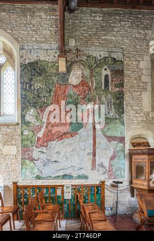 Wandgemälde von St. Christopher aus dem 14. Jahrhundert in der Kirche St. Mary Magdalene aus dem 12. Jahrhundert im Cotswold-Dorf Baunton, Gloucestershire, Großbritannien Stockfoto