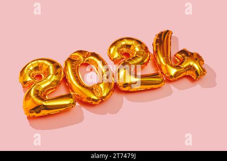Einige goldene Zahlenballons, die die Zahl 2024 als neues Jahr auf rosafarbenem Hintergrund bilden Stockfoto