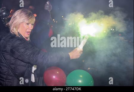 Magdeburg, Deutschland. November 2023. Magdeburgs Bürgermeister Simone Borris (keine Partei) hält einen Bengalo während der Ankunft des SC Magdeburg. Trotz des strömenden Regens wurde die Handballmannschaft des SC Magdeburg nach ihrem Sieg bei der Club-Weltmeisterschaft in Saudi-Arabien willkommen geheißen. Quelle: Ronny Hartmann/dpa/Alamy Live News Stockfoto