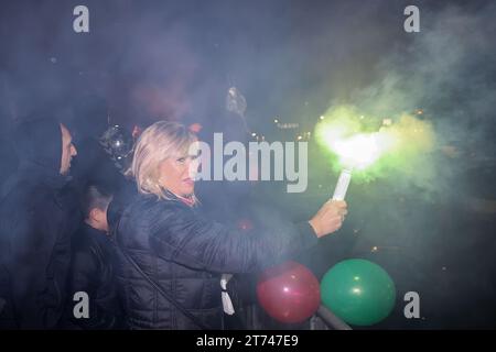 Magdeburg, Deutschland. November 2023. Magdeburgs Bürgermeister Simone Borris (keine Partei) hält einen Bengalo während der Ankunft des SC Magdeburg. Trotz des strömenden Regens wurde die Handballmannschaft des SC Magdeburg nach ihrem Sieg bei der Club-Weltmeisterschaft in Saudi-Arabien willkommen geheißen. Quelle: Ronny Hartmann/dpa/Alamy Live News Stockfoto