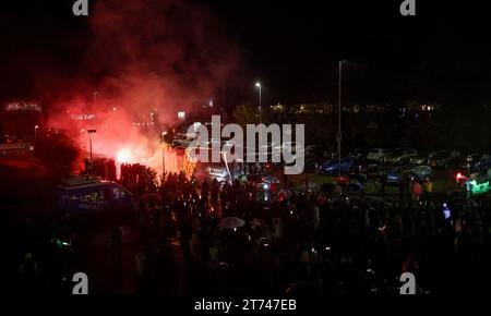 Magdeburg, Deutschland. November 2023. Der Mannschaftsbus des SC Magdeburg wird bei seiner Ankunft in Magdeburg von brennender Pyrotechnik beleuchtet. Trotz des strömenden Regens wurden die Handballspieler des SC Magdeburg nach ihrem Sieg bei der Club World Cup in Saudi Arabien willkommen geheißen Credit: Ronny Hartmann/dpa/Alamy Live News Stockfoto