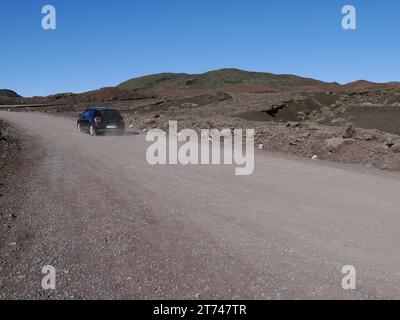 Schwarzes Auto fährt auf der Vulkanlandschaft zum Vulkan Fournaise, Plaine des Sables, Insel Réunion, Frankreich Übersee. La Réunion, Maskarene-Inseln. Stockfoto