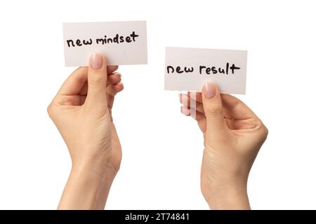 Neue Denkweise - neuer Ergebnistext auf einer Karte in einer Frauenhand isoliert auf weißem Hintergrund. Stockfoto
