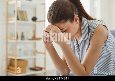 Frauen leiden unter Migräne, Stress und Depressionen am Arbeitsplatz aufgrund der Ausbeutung von Arbeitskräften. Stockfoto