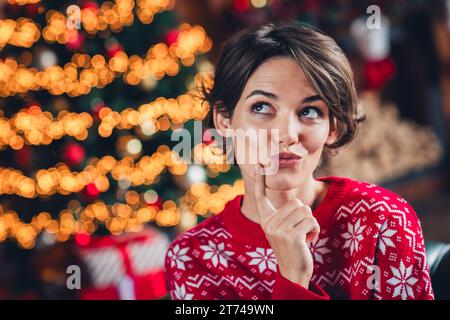 Foto-Porträt der nachdenklichen süßen netten träumenden Dame Touch Kinn hmm Wahl der besten Idee Überraschung weihnachten isoliert auf verschwommenem Hintergrund Stockfoto