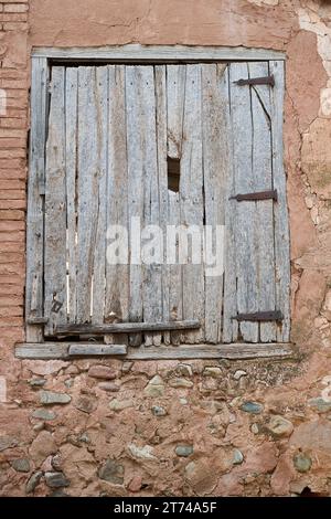 Blick auf das alte Holzfenster über die beschädigte Wand Stockfoto