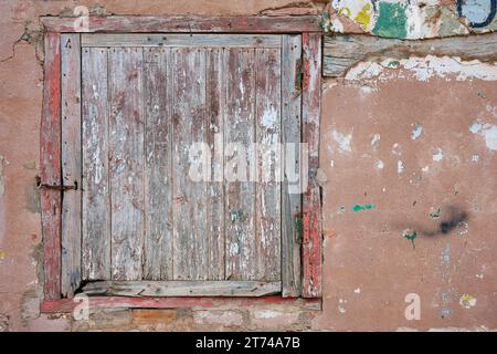 Blick auf das alte Holzfenster über die beschädigte Wand Stockfoto