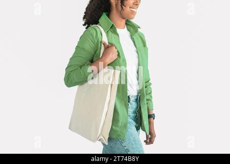 Umweltbewusste schwarze Frau mit Textil-Einkaufstasche, weißes Studio Stockfoto