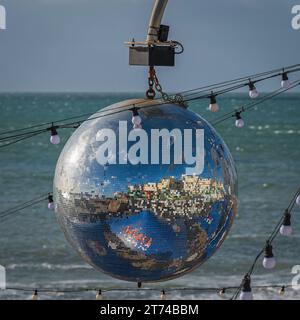 Brighton Seafront und Promenade spiegeln sich in einer Spiegelkugel in der Nähe des Palace Pier an der Küste in Brighton, Sussex, England, Großbritannien Stockfoto