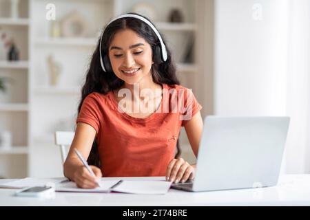 Fröhliche junge indische Studentin, die online studiert Stockfoto