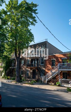 Bild eines schwarzen Hydranten vor zweistöckigen Gebäuden mit einem sichtbaren Balkon im Hintergrund Stockfoto