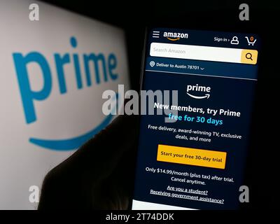 Person, die ein Mobiltelefon hält und die Webseite des Abonnementdienstes Amazon Prime vor dem Firmenlogo zeigt. Konzentrieren Sie sich auf die Mitte des Telefondisplays. Stockfoto