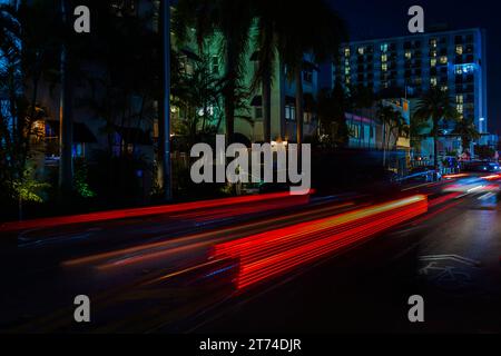 Nächtlicher Blick auf die Stadt Miami Beach mit atemberaubenden, unscharfen Lichtwegen von Autos auf der Collins Avenue. Florida. Miami Beach. USA. Stockfoto