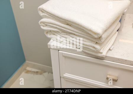 Nahaufnahme des Handtuchstapels auf dem weißen Nachttisch im Hotelbad. Stockfoto