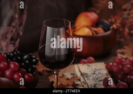 Herbstpicknick mit Wein- und Käseplatte, Früchten und trockenen Blättern Stockfoto
