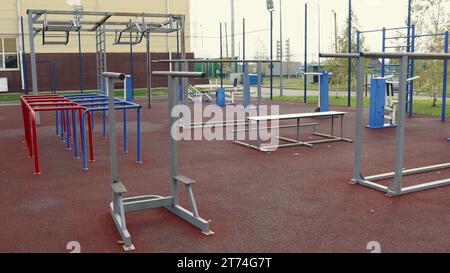 Outdoor-Fitnessgeräte aus Metall auf einem Sportplatz ohne Menschen, sportlicher Lebensstil in einem städtischen Raum, Geräte für Krafttraining auf der Straße Stockfoto