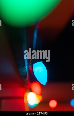 Nahaufnahme einer Reihe von Weihnachtslichtern, die in der Nacht leuchten. Stockfoto