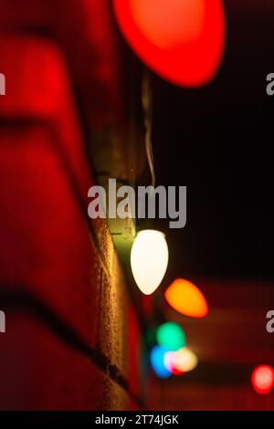 Eine Reihe von Weihnachtslichtern an der Außenseite eines Hauses in einer Dezembernacht. Stockfoto