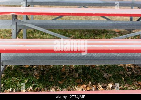 Nahaufnahme von roten Metall-Tribünen auf einem Leichtathletikfeld. Stockfoto